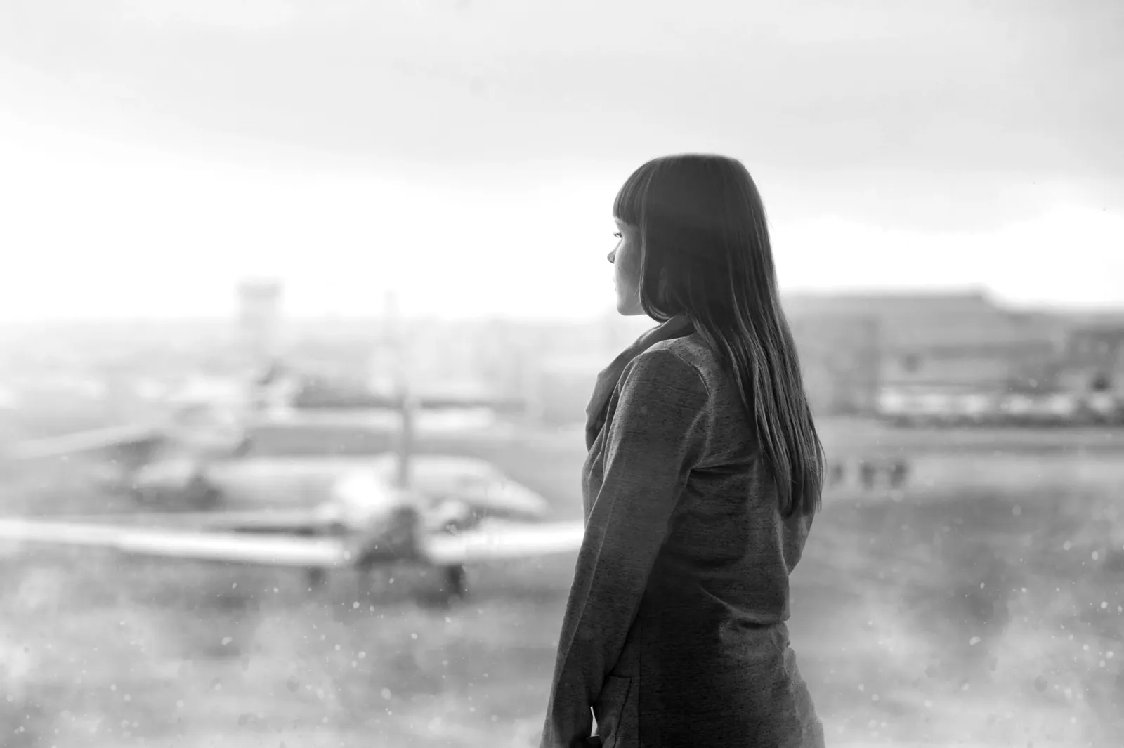 Traveller looking out over the runway at Glasgow Airport