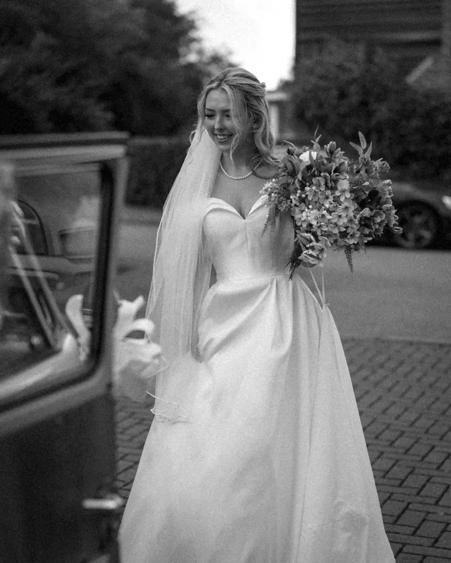 Bride stepping out of a chauffeur-driven wedding car